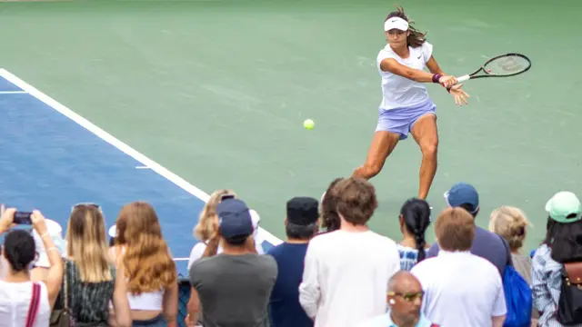 Emma Raducanu watched by fans on a practice court