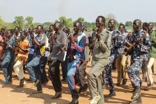 Police trainees, former soldiers of government and rebel groups, attend their training session with handmade wooden rifles or sticks and in civilian clothes at the unified training center in Rejaf on March 25, 2021.