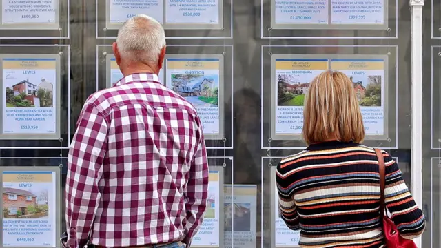 People looking in the window of an estate agent