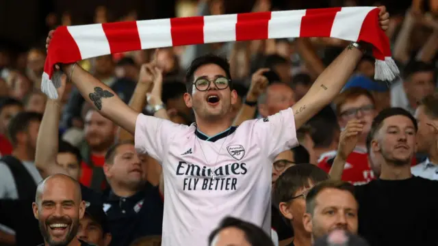 A photo of an Arsenal fan holding a scarf