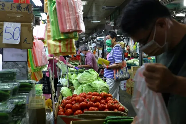 Customers shop at a market in Taipei