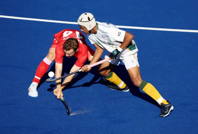 South Africa's Dayaan Cassiem in action with England's James Albery in the Commonwealth Games hockey men's bronze-medal match
