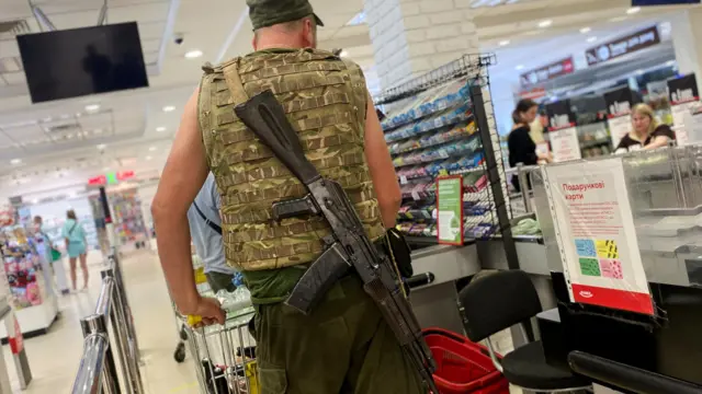 A Ukrainian serviceman pushes a trolley inside a supermarket in Kharkiv