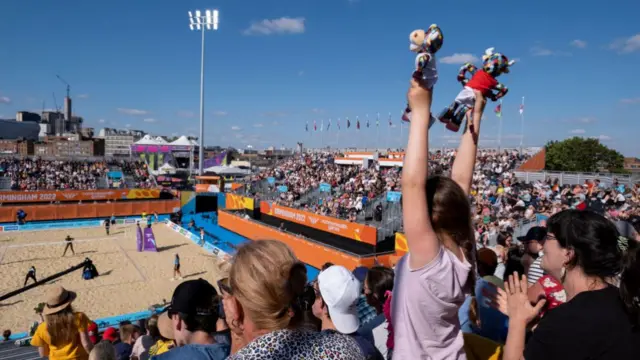 Fan with two Perry the bull mascot toys during Beach Volleyball