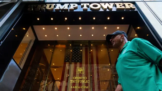 A man walks past the entrance to Trump Tower