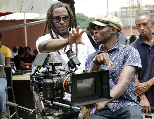 Film director Biyi Bandele (L) speaks to the cameraman on set.