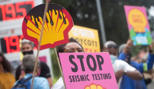 Activists and protesters stand along the M3 at the Shell garage in Newlands during a protest action against the 3D Seismic Survey commissioned By Shell along the West Coast on December 04, 2021