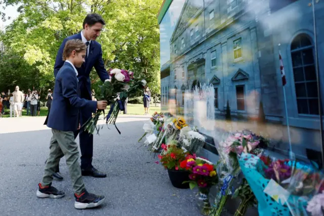 Canada's Prime Minister Justin Trudeau and son Hadrien lay flowers before a ceremony to proclaim the accession of King Charles III at Rideau Hall in Ottawa, Ontario, Canada