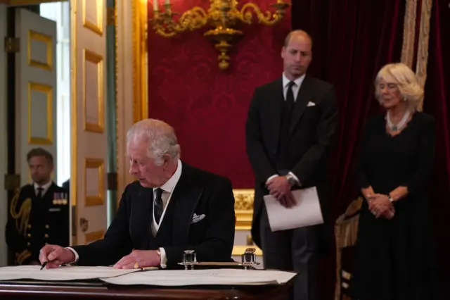 King Charles signs a piece of paper at the Accession Council