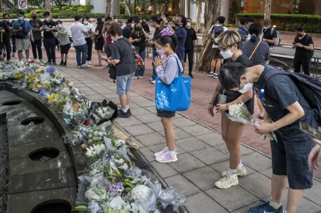 Hong Kongers laying flowers in tribute to the Queen at the British Consulate