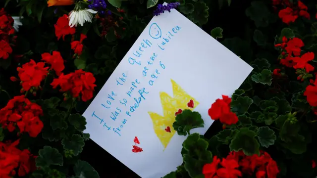 A card is seen amid floral tributes in a park near Buckingham Palace, following the passing of Britain's Queen Elizabeth, in London, Britain, September 10, 2022.