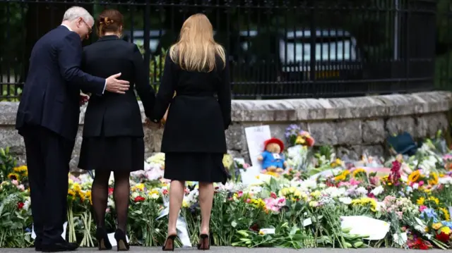 Britain's Prince Andrew and his daughters Princess Beatrice and Princess Eugenie view tributes outside Balmoral Castle