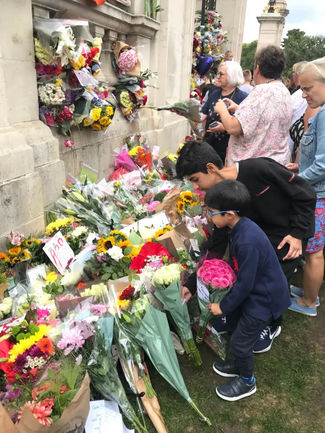 Brothers Zak and Kian lay flowers outside Buckingham Palace