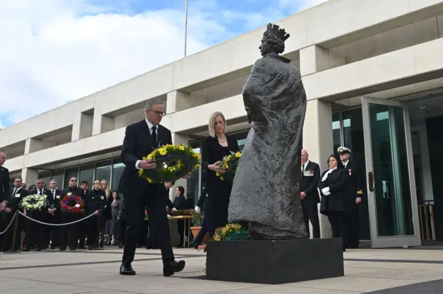 Prime Minister Anthony Albanese and Finance Minister Katy Gallagher laying wreaths at a statue of the Queen in Canberra