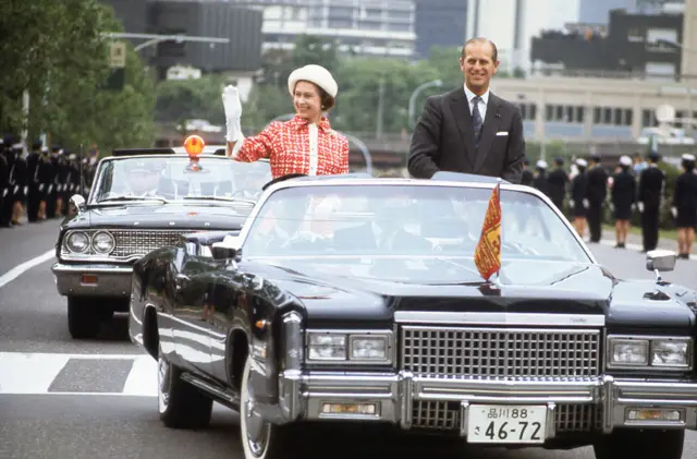 Queen Elizabeth and Prince Philip drive through Tokyo streets during a royal visit to Japan in May 1975