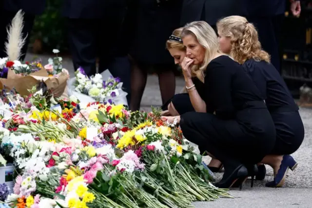 Lady Louise Windsor (R) Princess Beatrice of York (L) and Sophie, Countess of Wessex look at floral tributes outside Crathie Kirk church on September 10, 2022.