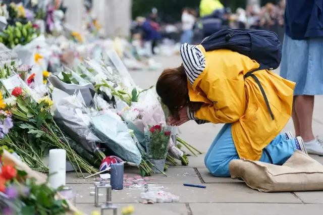 A woman mourns outside Buckingham Palace