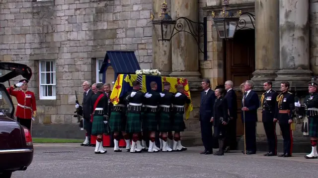 The coffin is carried into Holyroodhouse