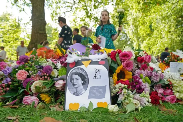 Members of the public laying floral tributes in Green Park, near Buckingham Palace, London