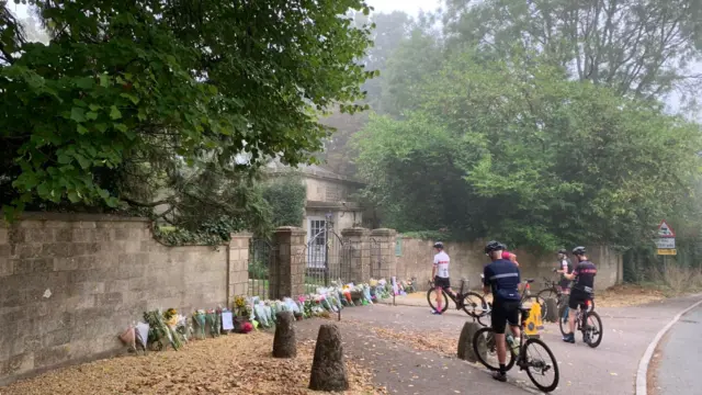 Cyclists stop at the gates near Highgrove House