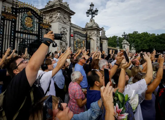 People gathered outside Buckingham Palace trying to get a picture of King Charles III on his way to Westminster Hall