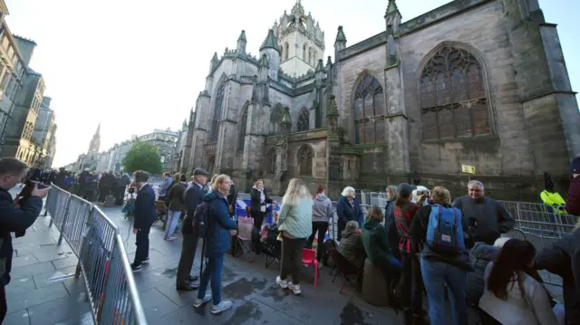 People gather outside St Giles' Cathedral, in Edinburgh, ahead of the Procession of Queen Elizabeth's coffin