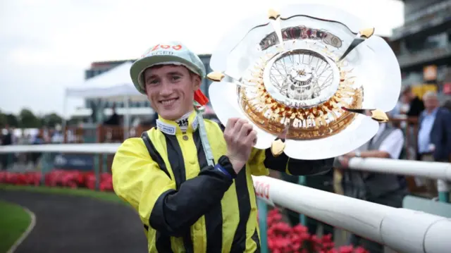 Jockey David Egan celebrates with the trophy after riding Eldar Eldarov to win the Cazoo St Leger Stakes at Doncaster Racecourse on Sunday