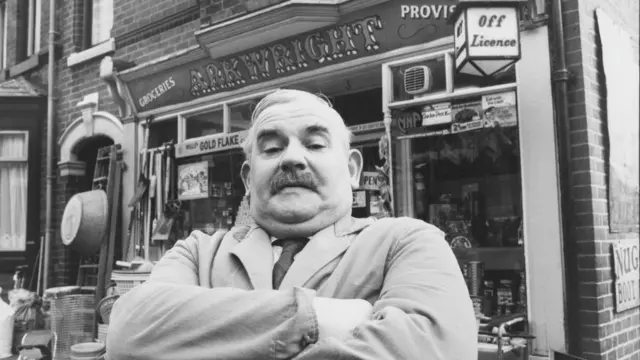 actor Ronnie Barker outside the 'Arkwright' general store, during filming for the television sitcom 'Open All Hours' in 1976