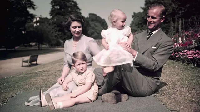 the Queen and Prince Philip with a young Prince Charles and Princess Anne on a picnic rug in the grounds of Balmoral in 1953