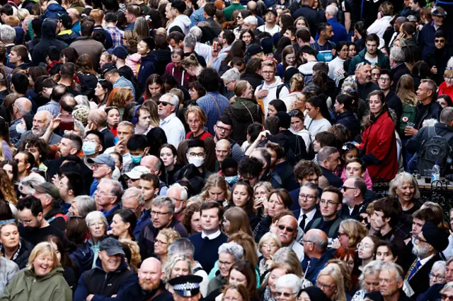 Crowds of people wait at Mercat Cross