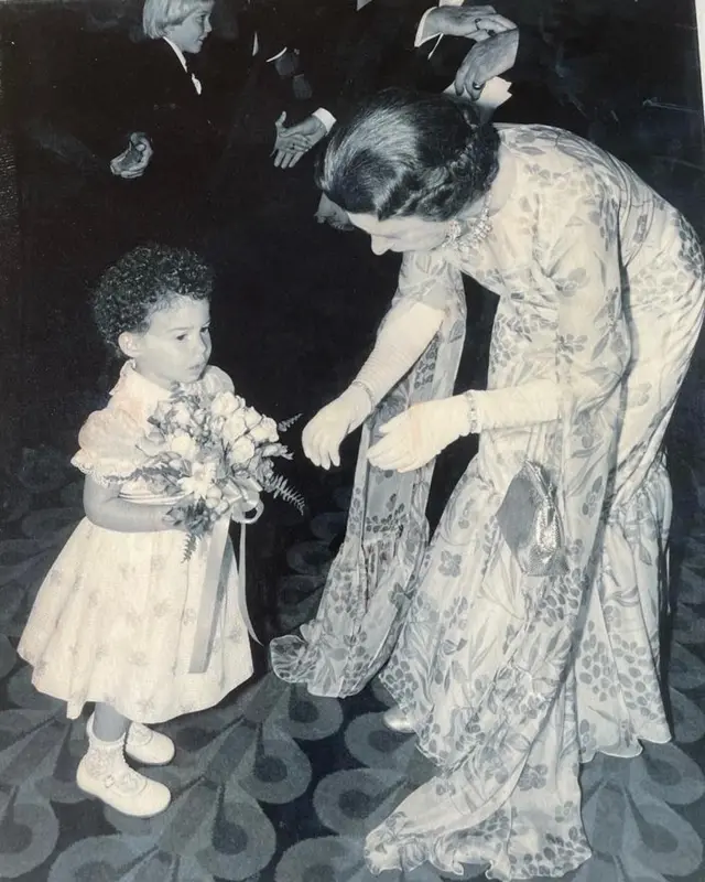 Child holding onto a bouquet meant for the Queen