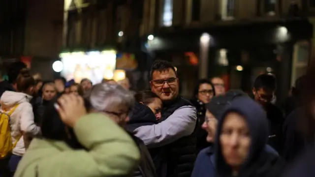 A couple hugging in the line