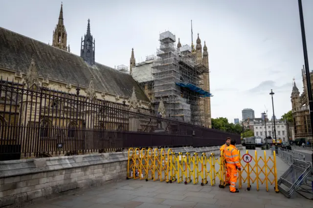 Workers close the pavement outside the Houses of Parliament