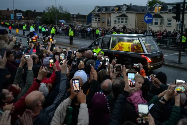 Thousands line the street to watch the Queen's hearse pass on its way to Buckingham Palace