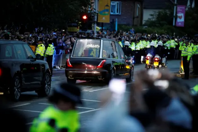 People gather to watch the hearse carrying Queen's coffin as it travels from RAF Northolt to Buckingham Palace