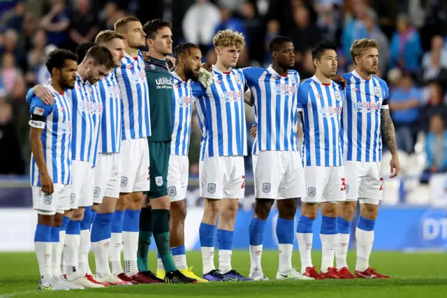 Huddersfield players stand in silence