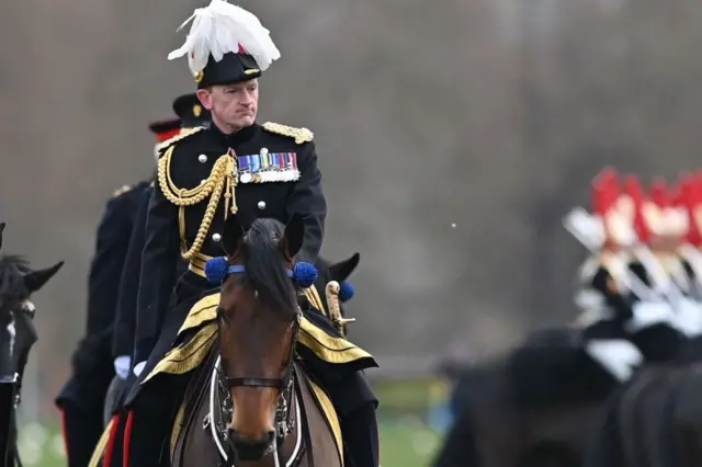 Major General Christopher Ghika rides on horseback earlier this year