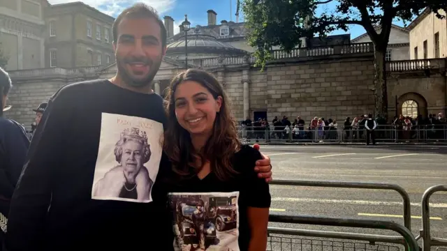 William Keshishan and Elin Mikaelian wearing shirts featuring pictures of the Queen