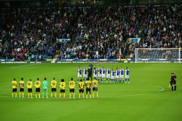 Watford and Blackburn players stand for the silence