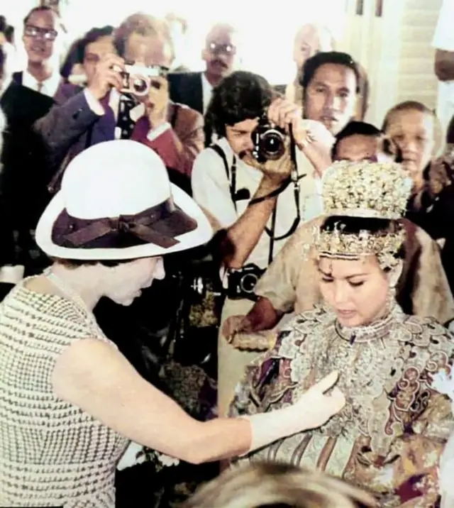 The Queen looking at a Malaysian woman's jewellery