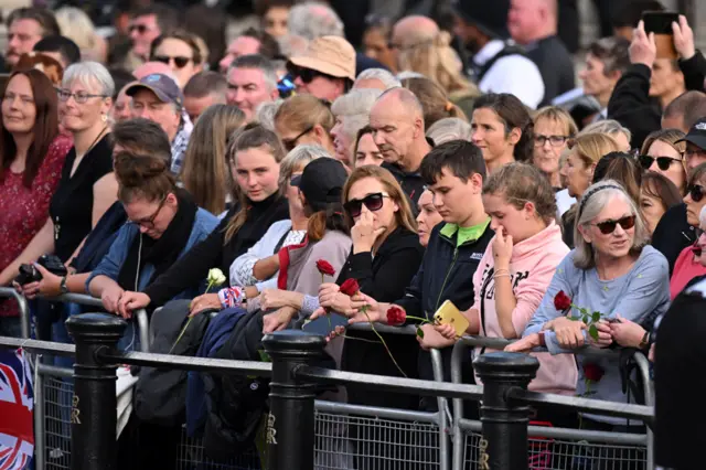 People line the streets during the procession of the coffin of Queen Elizabeth II