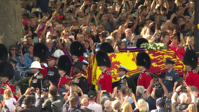 People holding phones up high as the Queen's coffin passes