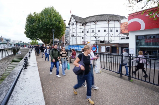 Members of the public in the queue on the South Bank, London, by the Globe Theatre