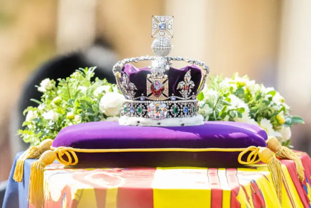 Queen Elizabeth II's coffin, adorned with a Royal Standard and the Imperial State Crown is taken in procession on a Gun Carriage of The King's Troop Royal Horse Artillery from Buckingham Palace to Westminster Hall on September 14, 2022 in London