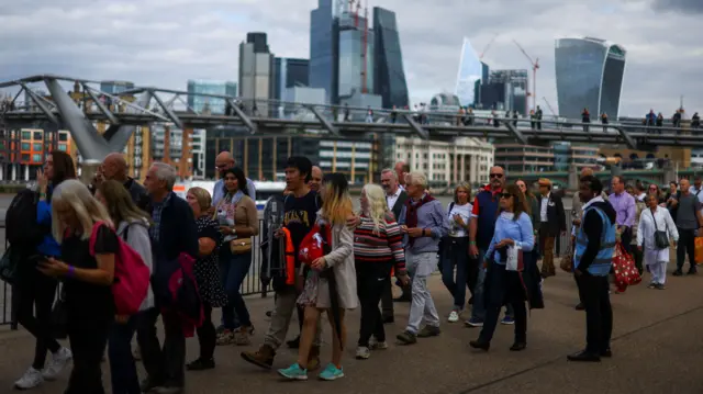 People queue along the River Thames to get into Westminster Hall and pay their respects to the Queen