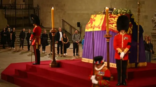 Members of the public file past as soldiers of the Grenadier Guards and Yeomen of the Guard stand guard around the coffin of Queen Elizabeth II, inside Westminster Hall.