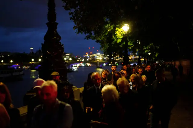 People wait opposite the Palace of Westminster on Thursday evening.