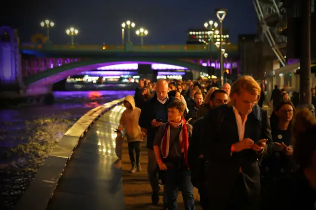 People lining up at night to see the Queen in London.