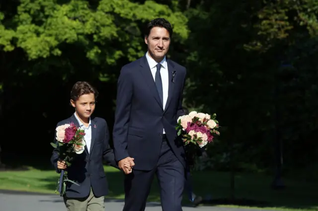 Justin Trudeau and his son Hadrien bring flowers for a memorial to Queen Elizabeth II.