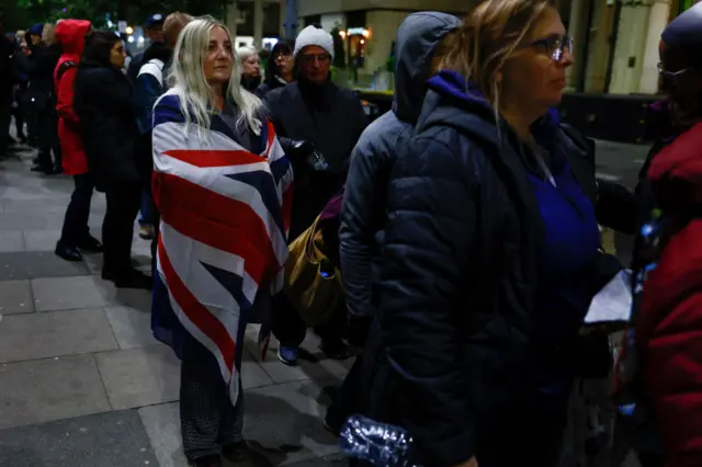 embers of the public stand spend their evening in a queue for the lying in state of Queen Elizabeth II on September 16